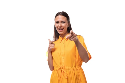 young friendly brunette woman dressed in a summer yellow dress attracts attention