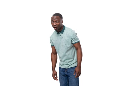 young friendly african guy with short haircut dressed in mint t-shirt with collar