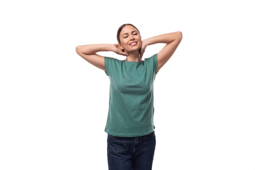 30 year old positive brunette woman with collected hair is dressed in a green basic t-shirt on an isolated white background