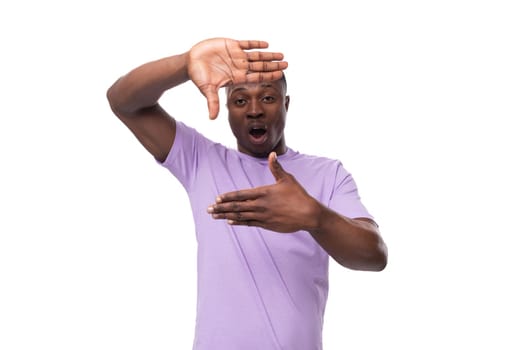 young well-groomed african man with a short haircut is dressed in a lilac t-shirt on a white background with copy space