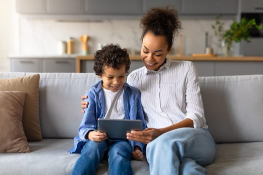 Black mother and son enjoying time together with tablet