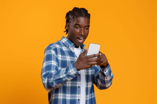 Great App. Amazed young black man looking at smartphone screen with excitement