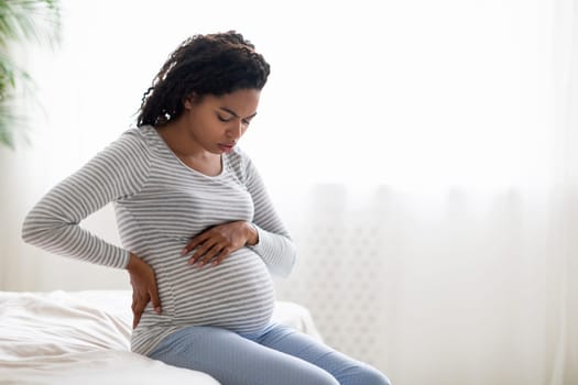 Pregnant black woman with contractions, feeling unwell at home
