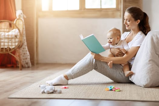 Happy loving young mother and her baby son reading book