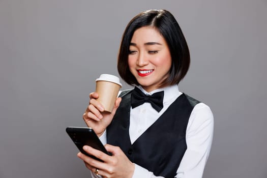 Waitress with phone holding coffee mug