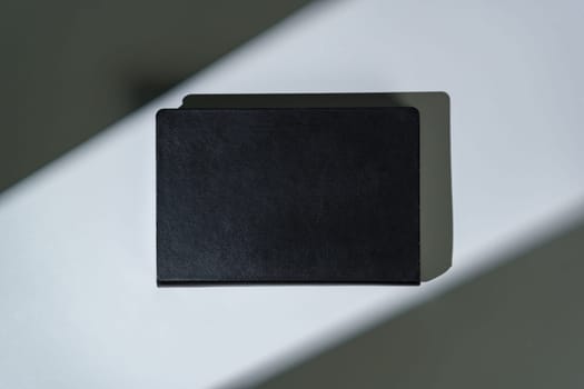 Black notepad with hard cover on gray background