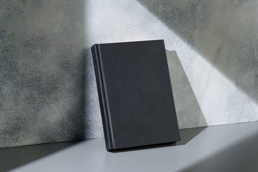 Black notepad with hard cover on gray background