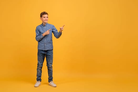 Look There. Cheerful Teen Boy Pointing At Copy Space With Two Hands