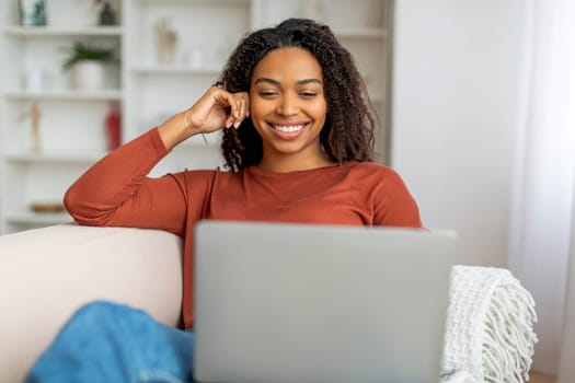Relaxed Young Black Woman Using Laptop Computer At Home