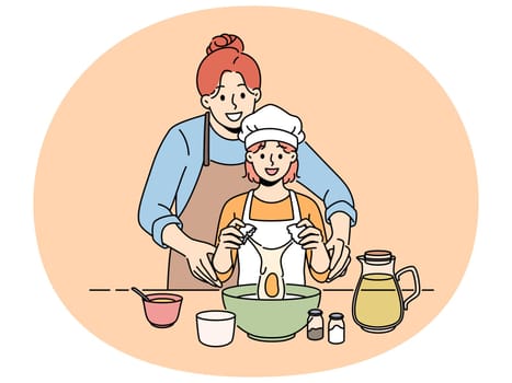 Smiling mother cook together with small daughter