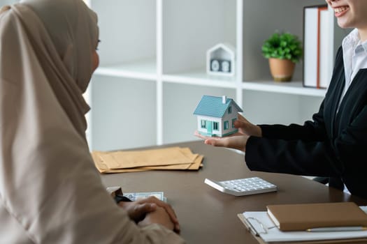 real estate agent talk about terms of home purchase agreement and ask Muslim customer to sign document to make the contract legally
