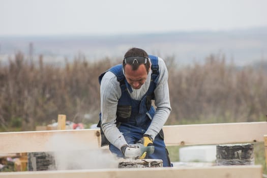 Building working - adult man with circular saw outdoors, small business