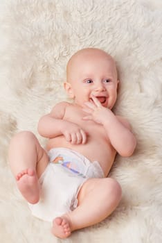 Happy baby, diaper and laugh in bedroom, furry blanket and playtime in cute for child development. Infant, kid and wellness for playing, adorable and positive on rug in house for home and toddler fun