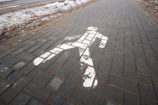 Pedestrian road symbol on dirty sidewalk closeup