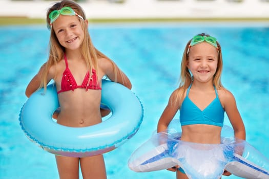 Summer, inflatables and portrait of kids at swimming pool, ready for adventure on vacation. Holiday, games and friends relax together with toys for fun, activity or children with safety gear in water