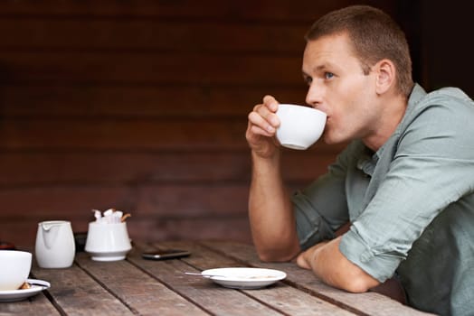 Thinking, idea and man at a cafe for coffee break, chilling or morning caffeine routine. Restaurant, tea cup and male person with moment of reflection, memory or calm contemplation while drinking