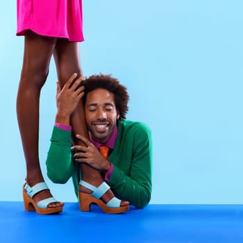 Couple, studio and smile with color, fashion and love with relationship and begging. African man, woman and dating with funky, vivid and bright worship with vintage or confession on blue background.