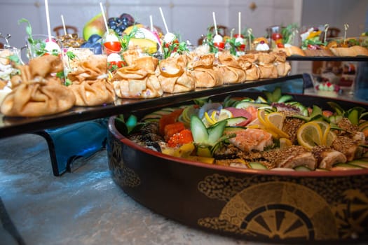 A buffet in a chic hotel with seafood, sushi, salads, fruits and pastries.