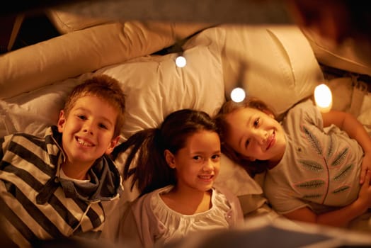Children, above and portrait of siblings in a bed with love, support and trust while bonding at home together. Family, night and face of kids in a bedroom for evening games, playing or indoor camping