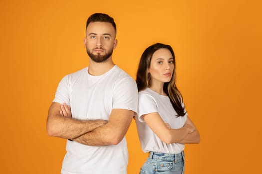 Confident young man and woman in white t-shirts, with arms crossed