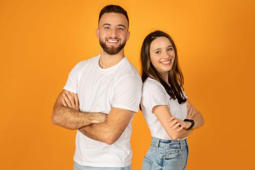 Smiling confident man and woman in white t-shirts with arms crossed, standing side by side