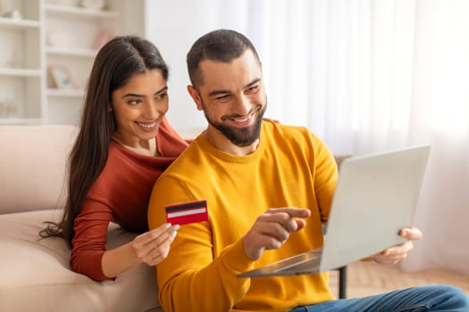 Young Spouses Making Online Shopping At Home With Laptop And Credit Card