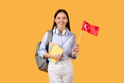 Joyful female student with Turkish flag and headphones