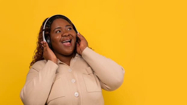 Positive overweight african american woman listening to her favorite song