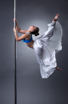 Sexy dancer turning gracefully around pole