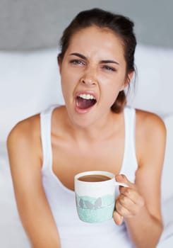 Woman, tired and yawning with coffee in bed, waking up from sleeping or nap with morning routine at home. Insomnia, fatigue and sleepy in bedroom, warm drink or beverage for breakfast and start day.