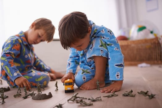 Boys, playing and children in pajamas with toys for fun with action figures, car or games. Brothers, child development and young kids bonding together in playroom for learning at family home