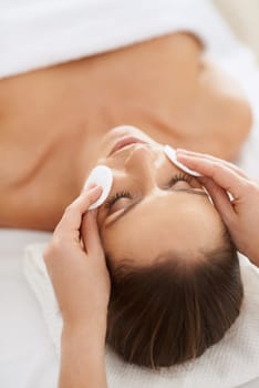 Woman, pad and facial massage for cosmetics treatment to relax, cleaning and beauty therapy for skin care. Female person, calm and serene or dermatology, closeup and rest at hotel and peace or zen