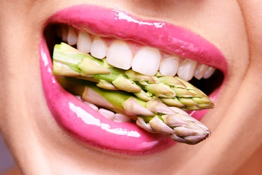 Woman, lipstick and closeup of vegetable in mouth for beauty, nutrition and healthy with vegan cosmetic product. Cruelty free makeup, cosmetology and asparagus, pink lip gloss for aesthetic or art