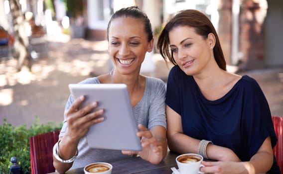 Cafe, women and smile together with tablet for social media meme or online joke, video and bonding for friendship. Female friends, digital technology and browse internet, website and coffee outdoors