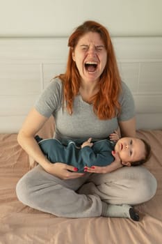 Vertical photo. A woman holds a child in her arms and cries. Postpartum depression.