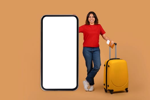 Middle eastern young woman with suitcase next to big phone
