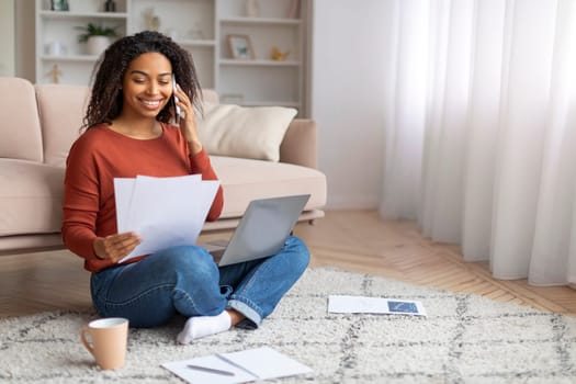 Remote Career. Black Woman Working At Home With Laptop, Cellphone And Papers