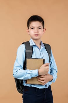 little cheerful school boy holding a book