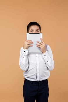 Emotional schoolboy holding digital tablet