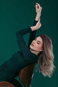 blonde woman posing in green dress on green background