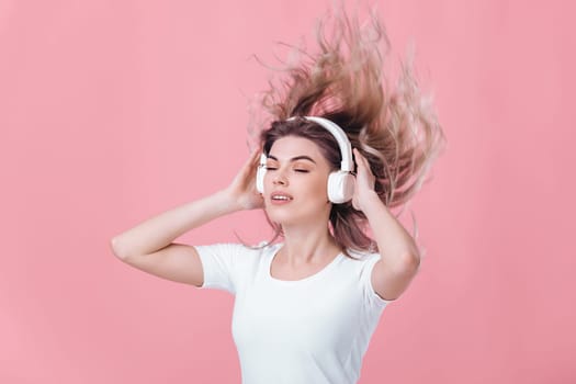beautiful blonde woman in white headphones listens to music