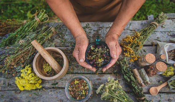 An elderly woman brews herbal tea. Selective focus.