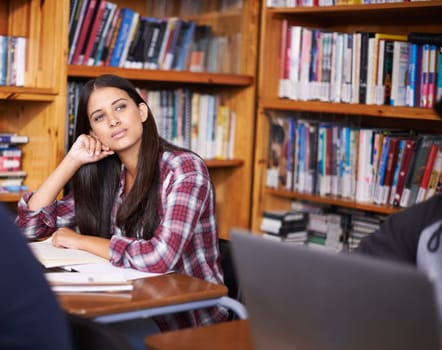 University student, thinking or studying in library for test or scholarship on campus for class assignment. Young, woman and happy for education learning and books for exam preparation by desk.