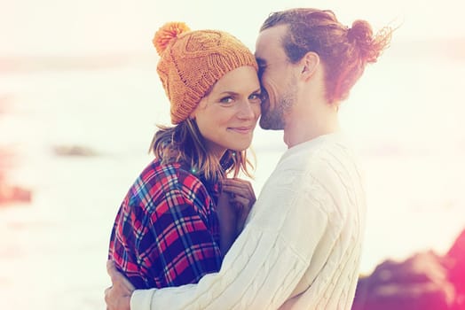 Beach, smile and portrait of couple hugging with love on vacation, adventure or holiday together. Happy, love and young man and woman embracing with care by ocean or sea on weekend trip in winter.