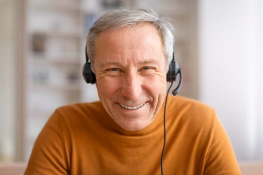 Closeup of senior man using headset smiling at camera