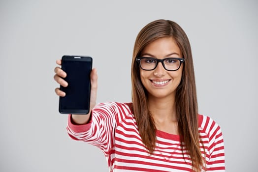 Portrait, happy woman and showing phone screen in studio isolated on white background. Face, smartphone or person with display for advertising, marketing or mockup space for social media with glasses