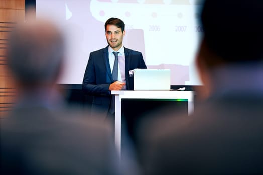 Business man, podium and presentation with projector screen, conference or workshop with laptop for slideshow. Corporate training, seminar and speaker with info, audience and professional speech