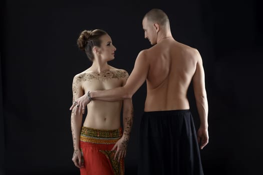 Nude yoga. Man covers woman's breast with his hand