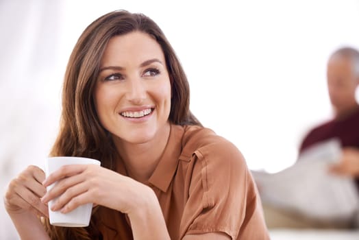 Woman, happy and coffee at home in the morning on a sofa with relax and calm thinking. Couple, couch and living room with a female person with smile and idea in a house lounge with hot drink.