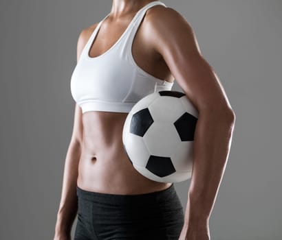 Woman, closeup and soccer player with ball for match, game or fitness on a gray studio background. Body of female person or athlete with football for sports exercise, workout or training on mockup
